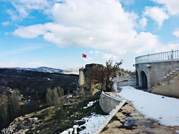 Flag on bridge against sky