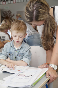 Teacher helping boy at school