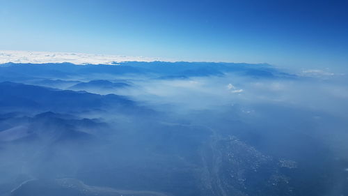 Aerial view of majestic mountains against blue sky
