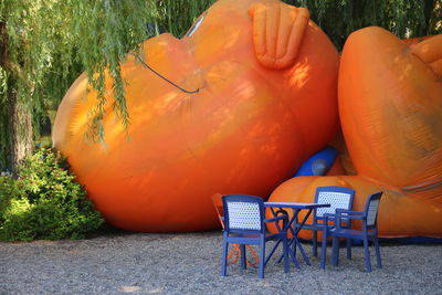 Table and chairs by inflatable dog at park