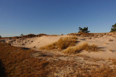 Scenic view of desert against clear blue sky