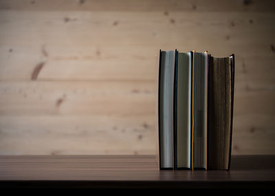 Close-up of open book on table against wall