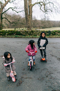 High angle view of siblings playing on push scooter