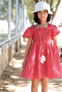 Low angle view of girl wearing hat standing outdoors at the zoo