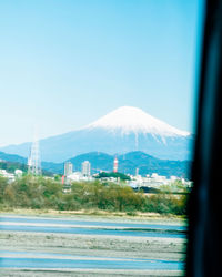 Scenic view of sea and mountains against clear blue sky