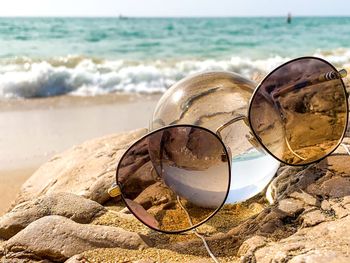 Close-up of sunglasses on beach
