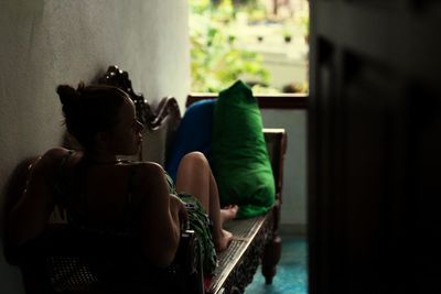 Rear view of woman relaxing on sofa at home