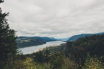 Scenic view of river and mountains against sky