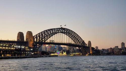 Bridge over river against sky during sunset