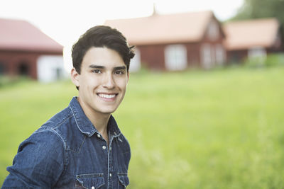 Portrait of confident young man smiling in yard