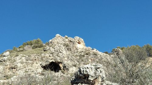 Low angle view of mountain against clear blue sky