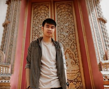 Portrait of young man standing against temple