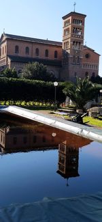 Buildings by swimming pool in city against sky