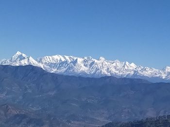 Scenic view of snowcapped mountains against clear blue sky