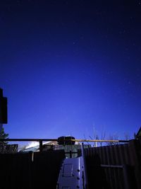 Low angle view of buildings against blue sky at night