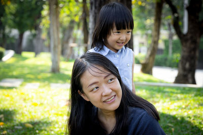 Portrait of a smiling young woman against plants