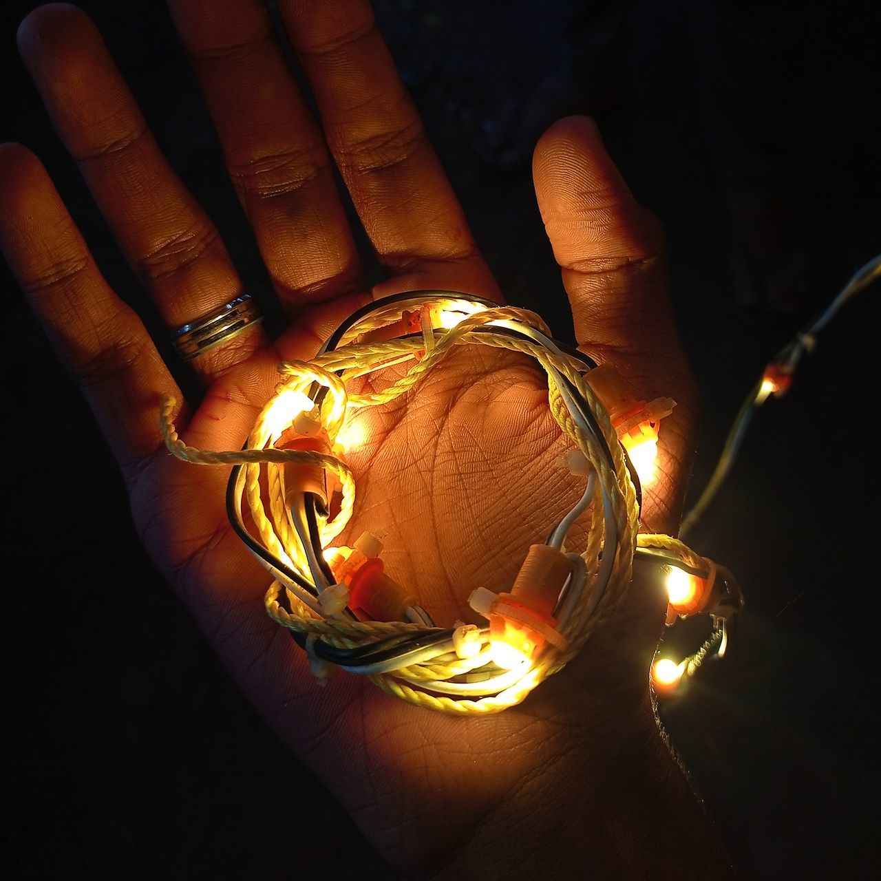 hand, yellow, light, lighting, one person, darkness, holding, illuminated, finger, indoors, night, close-up, lighting equipment, burning, glowing, candle, fire, flame, gold, macro photography, incandescent light bulb, adult, jewellery