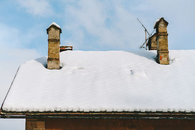 Snow covered roof against sky