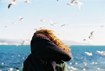 Close-up of woman with face covered by shawl against sea