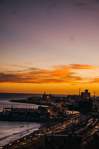 High angle view of illuminated city against sky during sunset