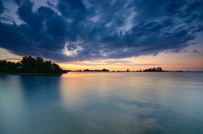 Scenic view of sea against dramatic sky during sunset