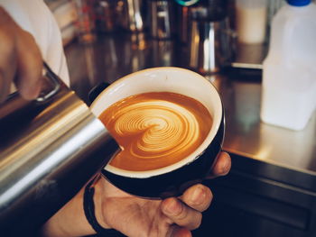 Close-up of hand holding coffee cup