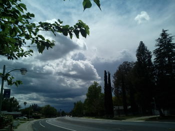 Empty road against cloudy sky