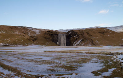 Scenic view of snow covered land against sky