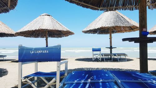 Lounge chair with thatched umbrella on tropical beach