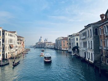 Boats in canal amidst buildings in city