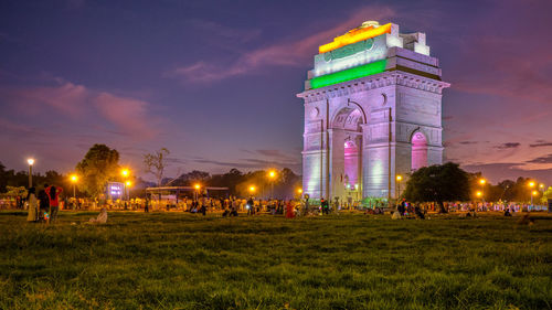 Crowd at illuminated park against sky at night