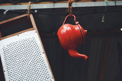 Low angle view of abandoned grater and teapot hanging on roof