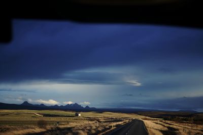 Scenic view of field against cloudy sky