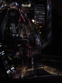 Light trails on road amidst illuminated buildings in city at night