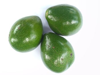 Close-up of green fruits against white background