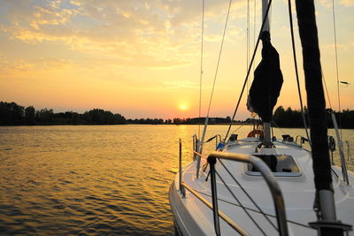 Sailboats in sea during sunset