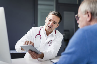 Doctor showing tablet to patient in medical practice