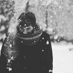 Man by snowfall standing on field