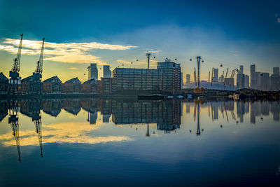 Reflection of buildings in lake during sunset