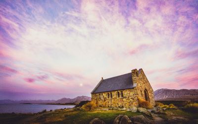 House by sea against sky during sunset