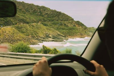 Close-up of man driving car on road