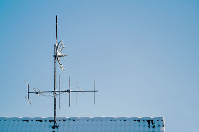 Low angle view of communications tower against clear blue sky