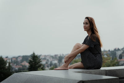 Portrait of young woman sitting on table