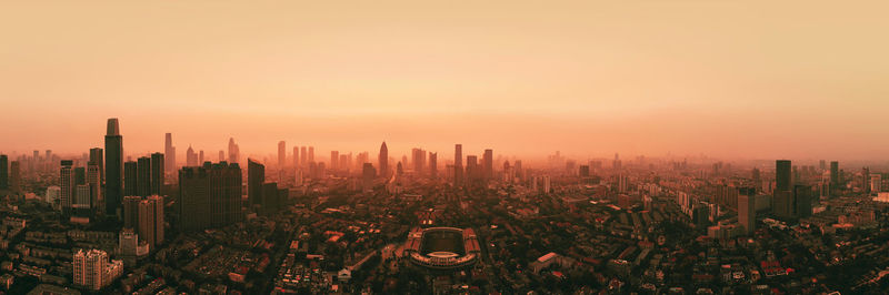 High angle view of modern buildings against sky during sunset