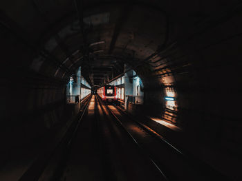 Train at railroad station platform seen through tunnel