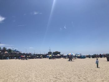 People on beach against blue sky