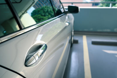 Door handle of modern car parked at parking lot of condominium, keyless entry door handle