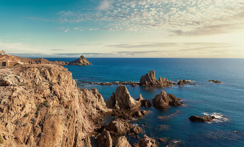 Scenic view of rock formations by sea at cabo de gata-nijar natural park during sunset