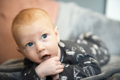 Close-up of adorable newborn baby boy sucking his hand or finger thumb