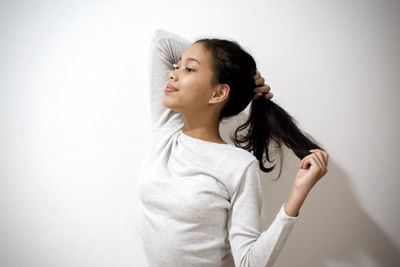 Portrait of a beautiful young woman against white wall